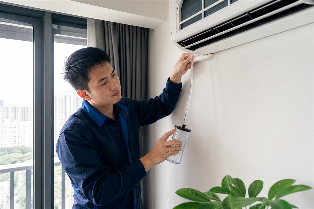 Technician checking an aircon drain line